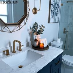 a bathroom with marble counter tops and blue cabinets