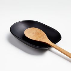 a black plate with a wooden spoon in it