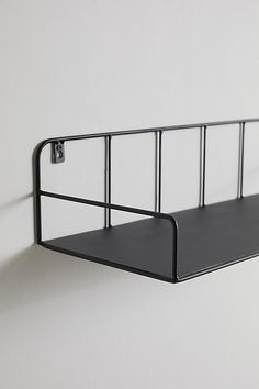 a black metal shelf mounted to the side of a wall