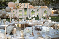 an outdoor baby shower is set up with white and gold decorations