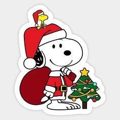 a snoopy christmas sticker with a santa hat on and a tree in the foreground