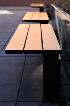 two wooden benches sitting next to each other on a sidewalk