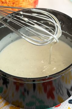 a whisk is being used to make batter in a pan on a table