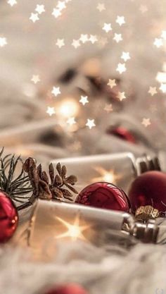 christmas decorations and presents on a white tablecloth with silver stars in the back ground