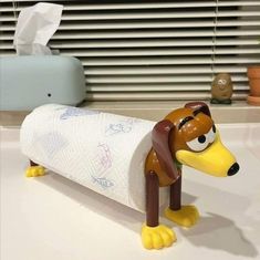 a toy dog that is holding a roll of toilet paper