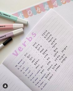 three pens sitting on top of a notebook next to some writing paper with words written in it