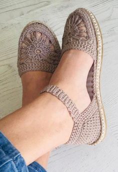 a woman's feet wearing crocheted shoes