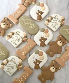 decorated cookies with teddy bears and balloons are arranged in the shape of letters that spell out one