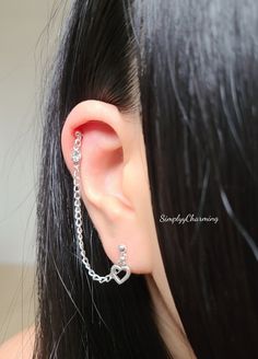 a woman's ear with a chain attached to the back of her ear,