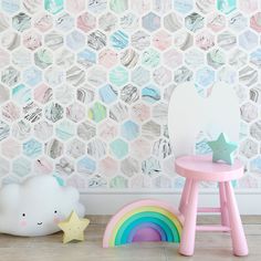 a child's room with a wallpaper design and rainbow toys on the floor