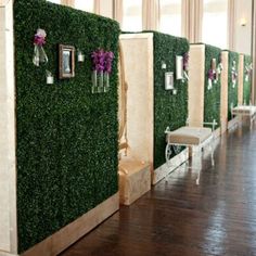 a row of chairs sitting next to each other in front of a wall covered with fake grass