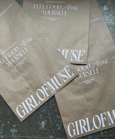 four brown paper bags with white lettering on them