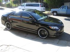 a black car is parked on the side of the road