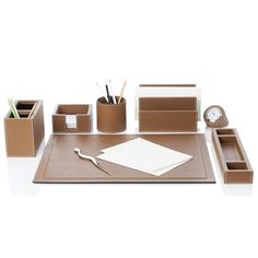 office supplies are arranged on top of a brown desk mat with pen and pencils