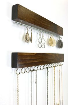 a wall mounted jewelry rack with several pairs of earrings hanging from it's sides