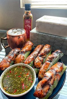 grilled vegetables on a blue plate with dipping sauce and condiments next to it