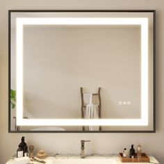 a bathroom sink with a lighted mirror above it