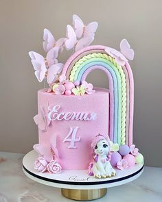 a pink cake with a rainbow on top