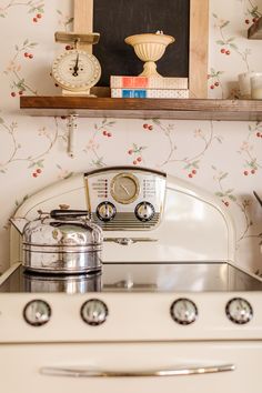 a white stove top oven sitting under a wooden shelf