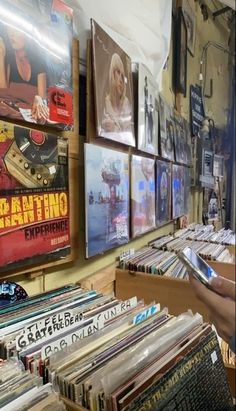 there are many records on display in the store and one person is looking at them