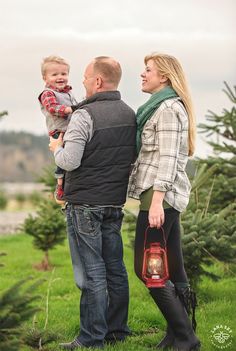 a man, woman and child are standing in the grass