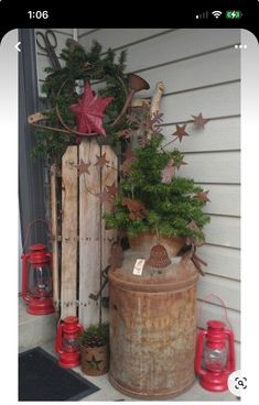 an old barrel is decorated with christmas decorations and other things to decorate on the front porch