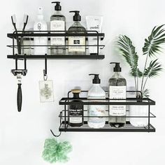 two black shelves with bottles and soaps on them next to a potted plant