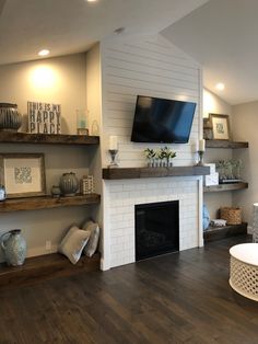 a living room filled with furniture and a flat screen tv mounted on the wall above a fireplace