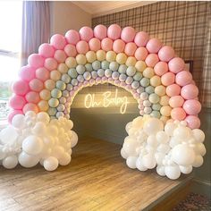 an arch made out of balloons with the word oh baby written on it in pink and white