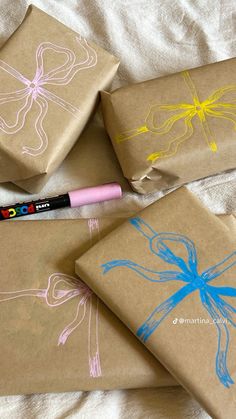 three wrapped gift boxes with designs on them and a crayon marker in the middle