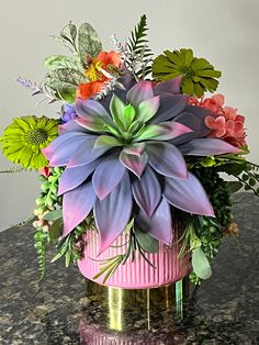 a pink vase filled with flowers on top of a table