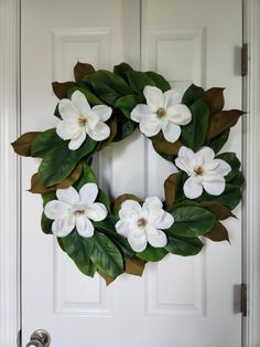 a wreath with white flowers and green leaves