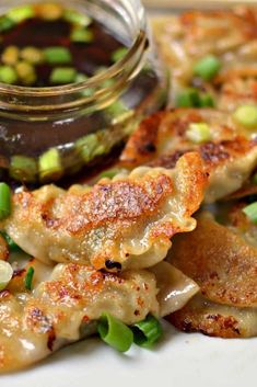 pork dumplings with steamed green onions and dipping sauce on the side, served in a glass jar