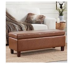 a brown leather bench sitting in front of a white couch