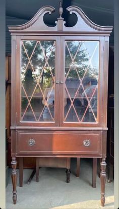 an old wooden cabinet with glass doors