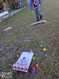 a young boy playing with plastic cups in the yard