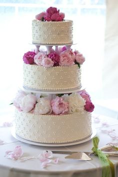 three tiered wedding cake with pink and white flowers