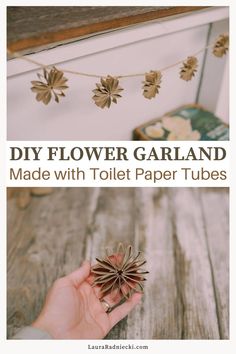 a hand holding a paper flower with the words diy flower garland made with toilet paper tubes