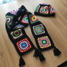 three crocheted hats and scarfs sitting on top of a wooden table