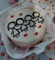 a white cake with black writing on it sitting on top of a paper wrapper