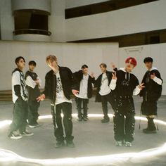 a group of young men standing next to each other in front of a white wall