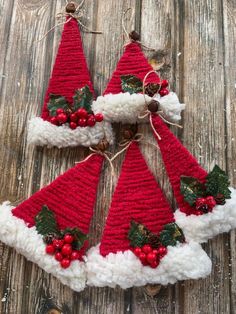 three crocheted christmas hats with holly berries and pine cones