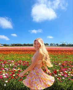 a woman standing in a field full of flowers