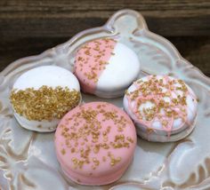 three different types of donuts with sprinkles on a glass plate next to a wooden table