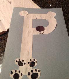 paper cut out of the shape of a letter p with paw prints and a bear's head