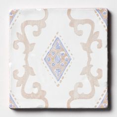 a white and blue tile with an intricate design on the bottom, sitting on a table