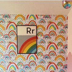 a room with a rainbow wallpaper and mirror hanging on the wall next to it