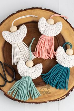 crocheted tassels are arranged on a wooden plate