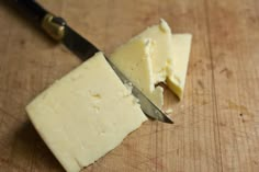 a piece of cheese is being cut with a knife