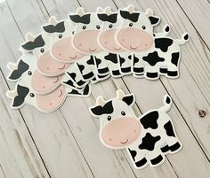 six cow stickers sitting on top of a wooden table next to eachother